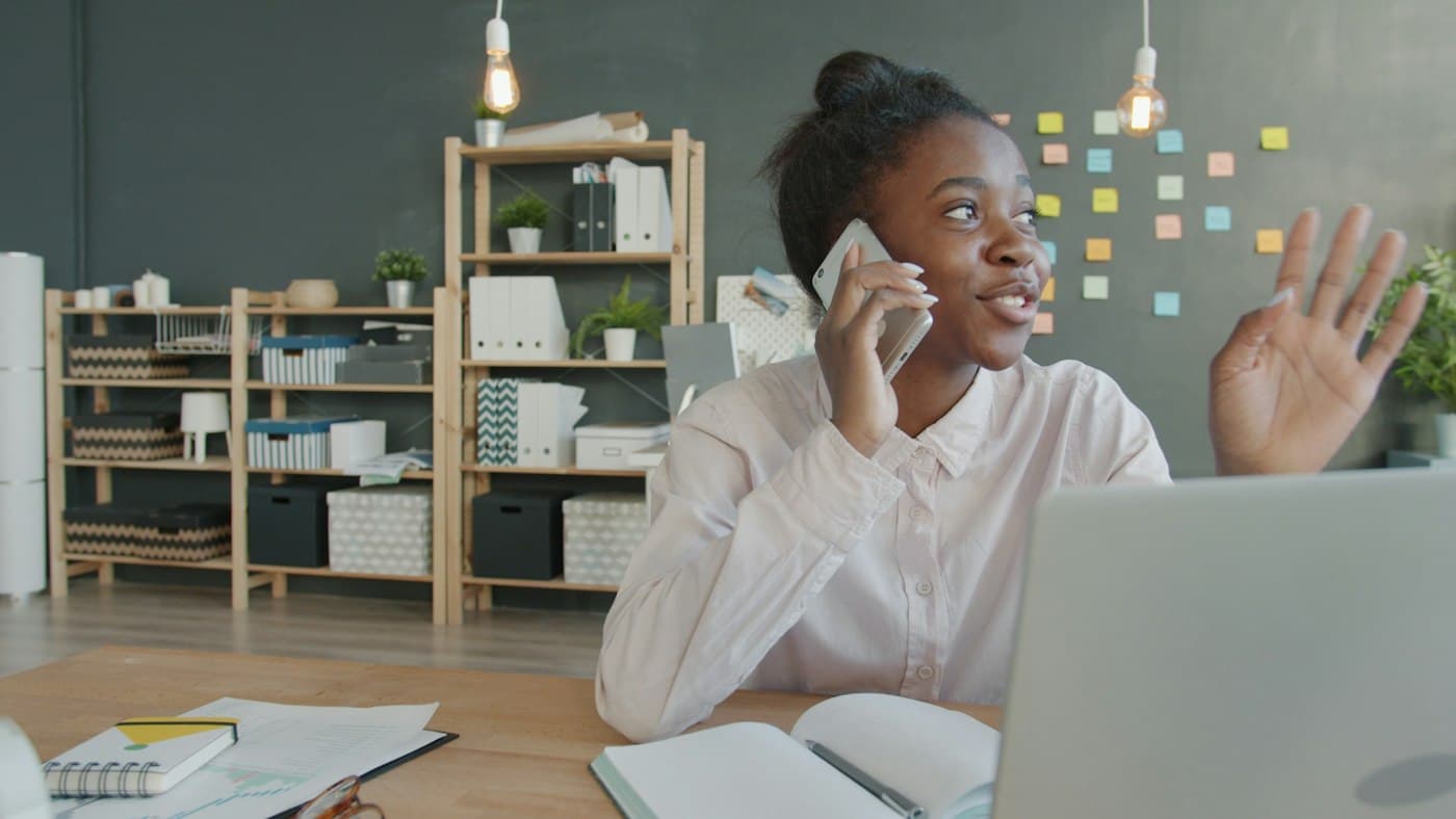 A young professional on a phone call at her desk
