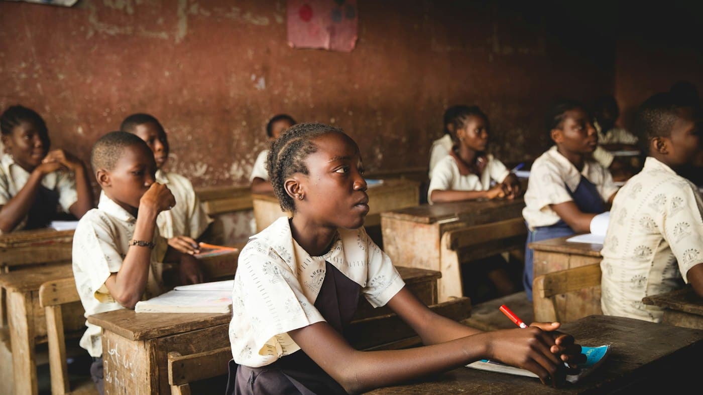 Pupils in uniform working at their desks in a classroom